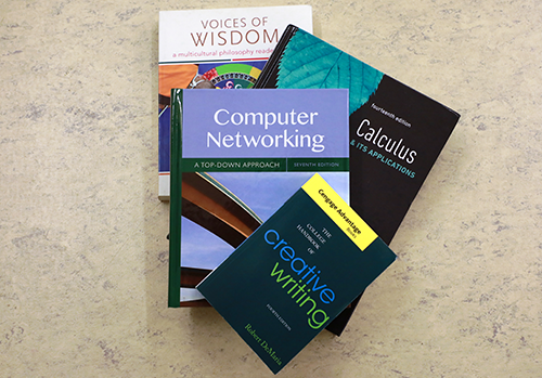 three textbooks sitting on desk